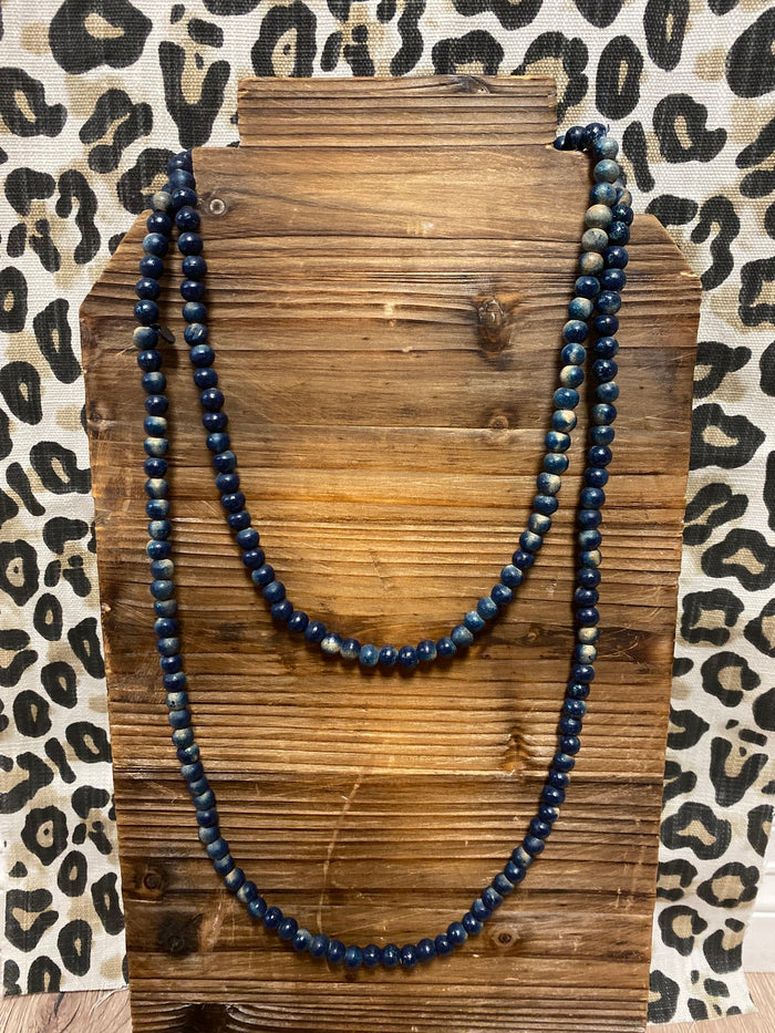 Braided cord necklace with gold tone wire wrapped navy blue faceted beads.  Approximately 14